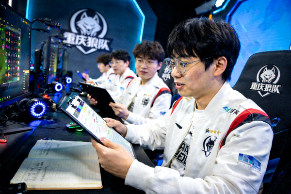 重庆狼队战队宣传照 - 战队成员在训练室中专注讨论战术